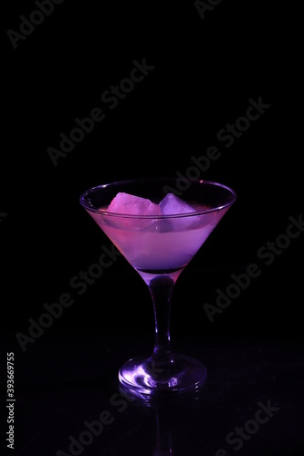 Glass with purple cocktail on black background