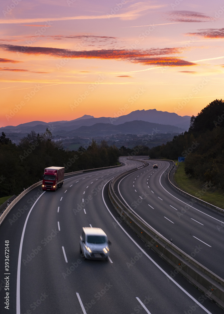 Fototapeta premium Truck traffic on the A8 motorway at dawn, city of Donostia, Euskadi