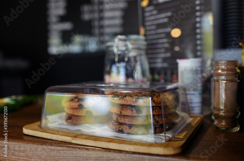 Tasty cookie at bar counter in coffee shop. Blurred image, selective focus