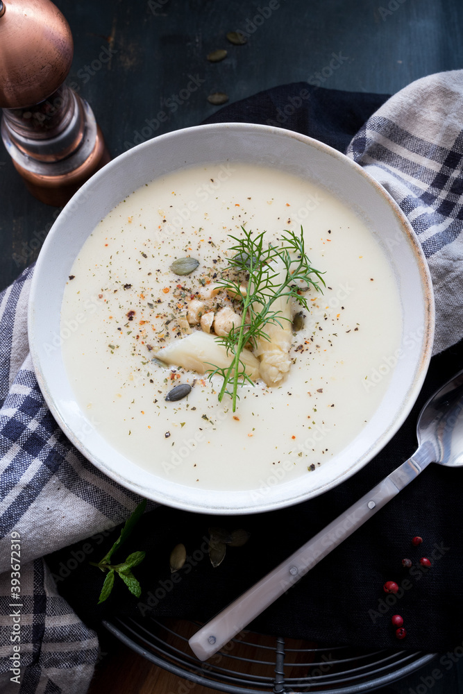 Closeup view of a delicious asparagus soup with a sprig of dill at the top.