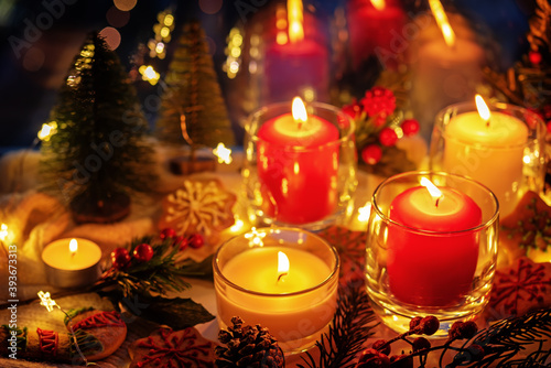 Winter Christmas holidays background with candles; christmas light; Cup of cocoa with marshmallow or hot chocolate near a windo