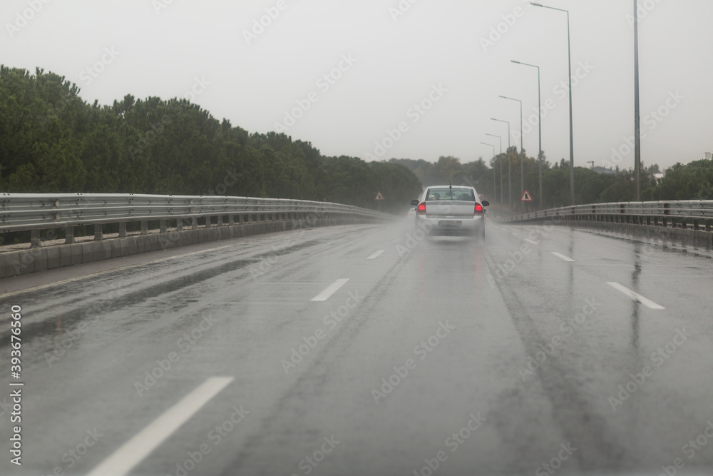 Cars driving along a wet highway in rainy weather