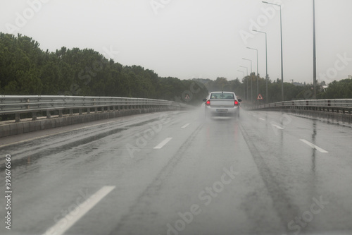Cars driving along a wet highway in rainy weather