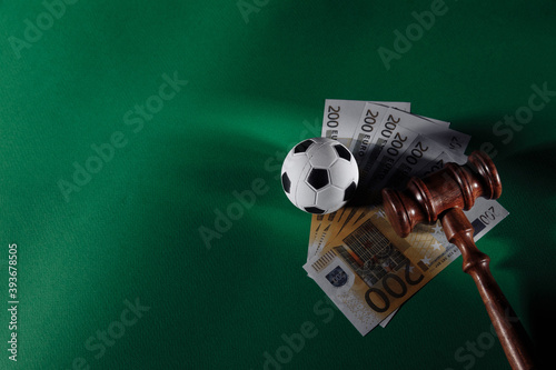 Fotografia Soccer ball and judge gavel on green background