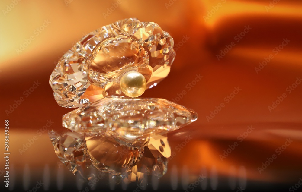 A pearl inside shell shiny crystal show piece isolated on beautiful golden background and the reflection lso seen A pearl inside shell shiny crystal show piece isolated on beautiful golden background and the reflection lso seen