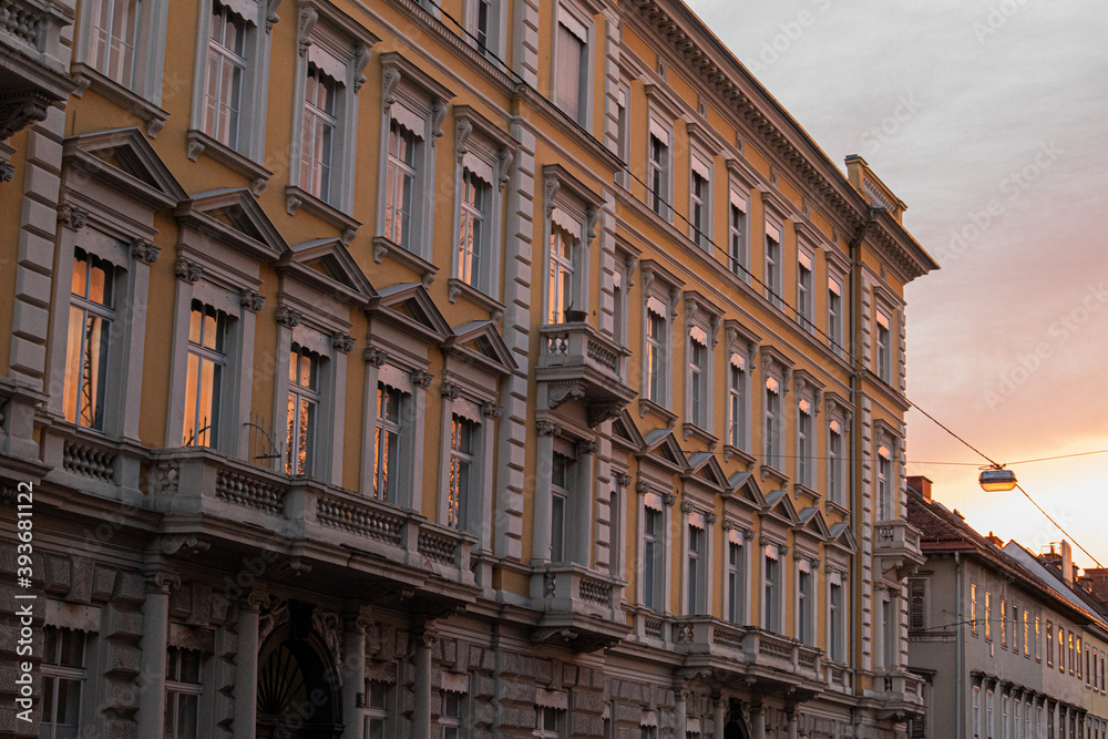 Fototapeta premium Spiegelungen in Fenstern von älteren Gebäuden bei Sonnenuntergang