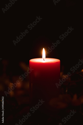 Merry Christmas concept with red burning candle on dark background, copy space