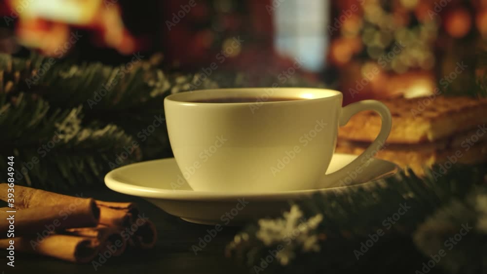 White cup of hot coffee on a brown wooden table. Green spruce branches, homemade waffles with souffle and cinnamon. Christmas lights on background. Cozy atmosphere. New Year and Christmas concept, 4K