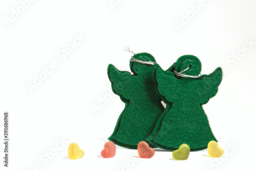 Obraz na płótnie Greeting a Christmas Card for xmas & New Year holiday season. The frame with a two green felt angeltoys and copy space for your text. Soft focus.In the foreground are five hearts. w salonie
