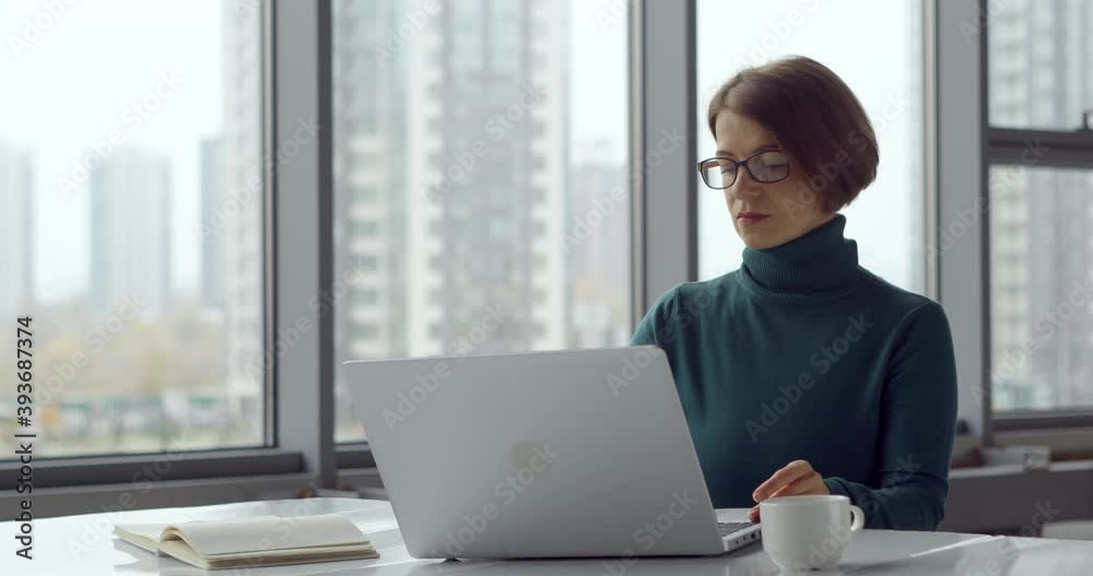 Portrait of a business woman working behind a laptop in a modern office. A woman freelancer uses a computer. Portrait of a business woman working behind a laptop in a modern office. A woman freelancer uses a computer.