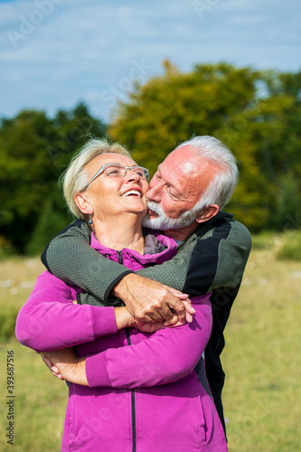 Wallpaper Mural Elderly couple embracing in autumn park. Enjoying in love. Torontodigital.ca