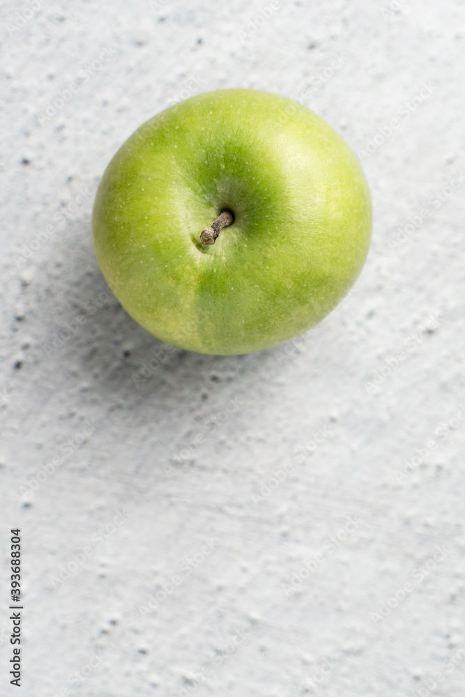One granny smith green apple on marble bright table with copy space One granny smith green apple on marble bright table with copy space
