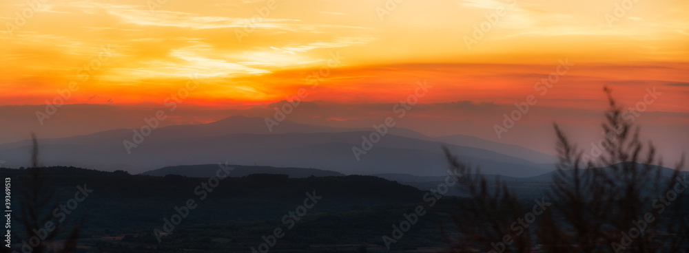Fototapeta premium Beautiful sunset panorama photo over the field and the top of mountains.
