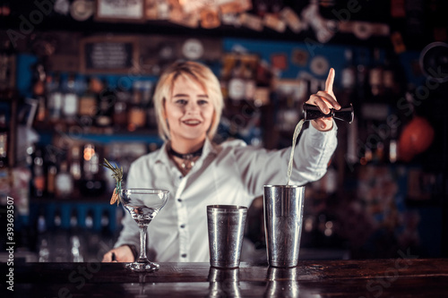 Girl barman formulates a cocktail in the porterhouse