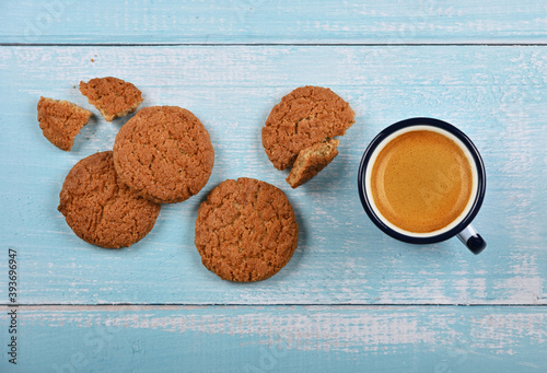 Oatmeal cookies and pannikin of coffee on blue table photo