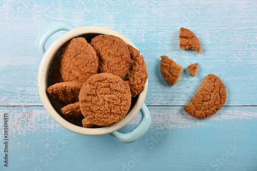 Oatmeal cookies in pannikin on blue table