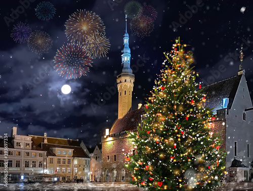 Christmas firework green  tree illuminated decoration  on hall town square in winter  Tallinn old town medieval city ,moon on night blue sky snow fall ,holiday in Estonia  photo