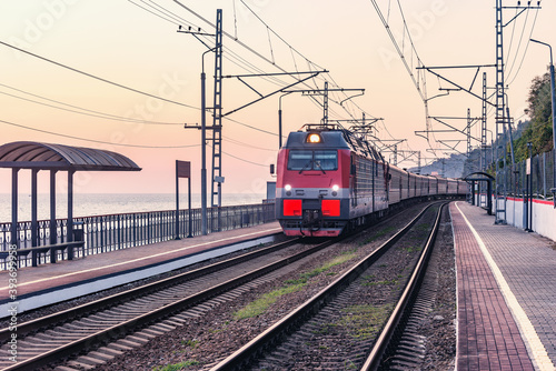 Passenger train moves along Black sea coast.. Sochi.