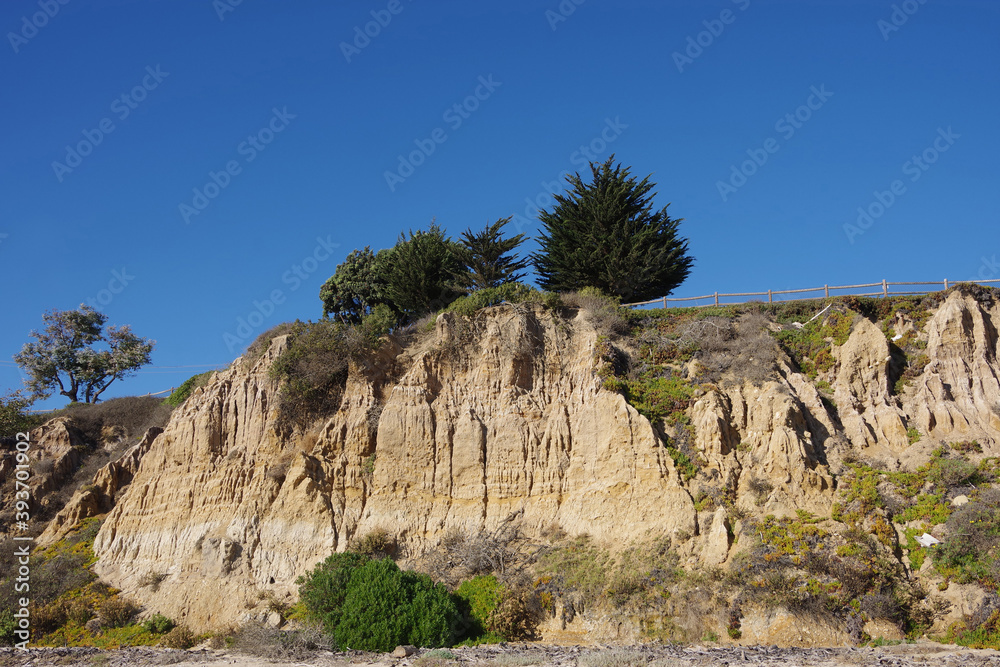 Low angle view of the bluffs and landscape above the pacific ocean beach in Summerland, California on a warm and sunny autumn day