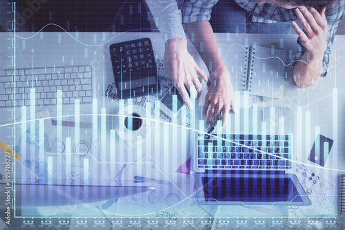 Double exposure of man and woman working together and financial graph hologram drawing. market analysis concept. Computer background. Top View.