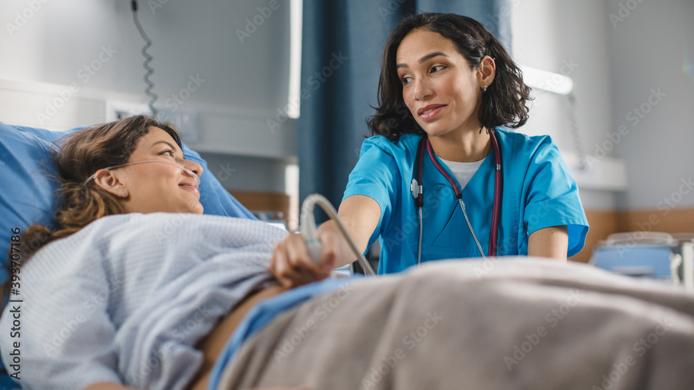 © Gorodenkoff - Hospital Ward: Happy Pregnant Hispanic Woman Getting Sonogram / Ultrasound Scan, Friendly Latin Female Obstetrician Moving Transducer on the Belly of the Future Mother and Talking About Healthy Baby. © Gorodenkoff - Hospital Ward: Happy Pregnant Hispanic Woman Getting Sonogram / Ultrasound Scan, Friendly Latin Female Obstetrician Moving Transducer on the Belly of the Future Mother and Talking About Healthy Baby.