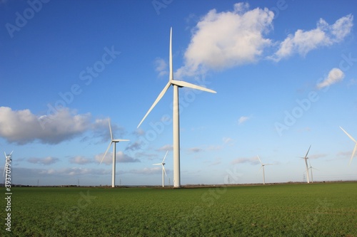 Wind farm turbines that produce electricity energy. Windmill Wind power technology productions Wind turbines standing in green field - stock footage © cheekylorns