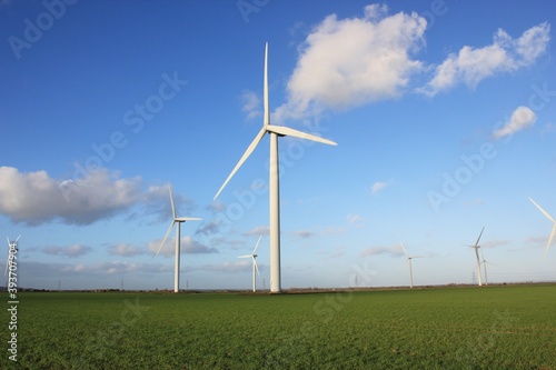 Wind farm turbines that produce electricity energy. Windmill Wind power technology productions Wind turbines standing in green field - stock footage