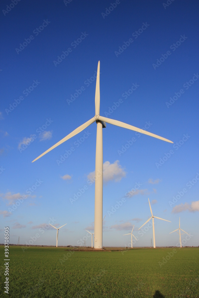 Wind farm turbines that produce electricity energy. Windmill Wind power technology productions Wind turbines standing in green field wind farm- stock footage Wind farm turbines that produce electricity energy. Windmill Wind power technology productions Wind turbines standing in green field wind farm- stock footage