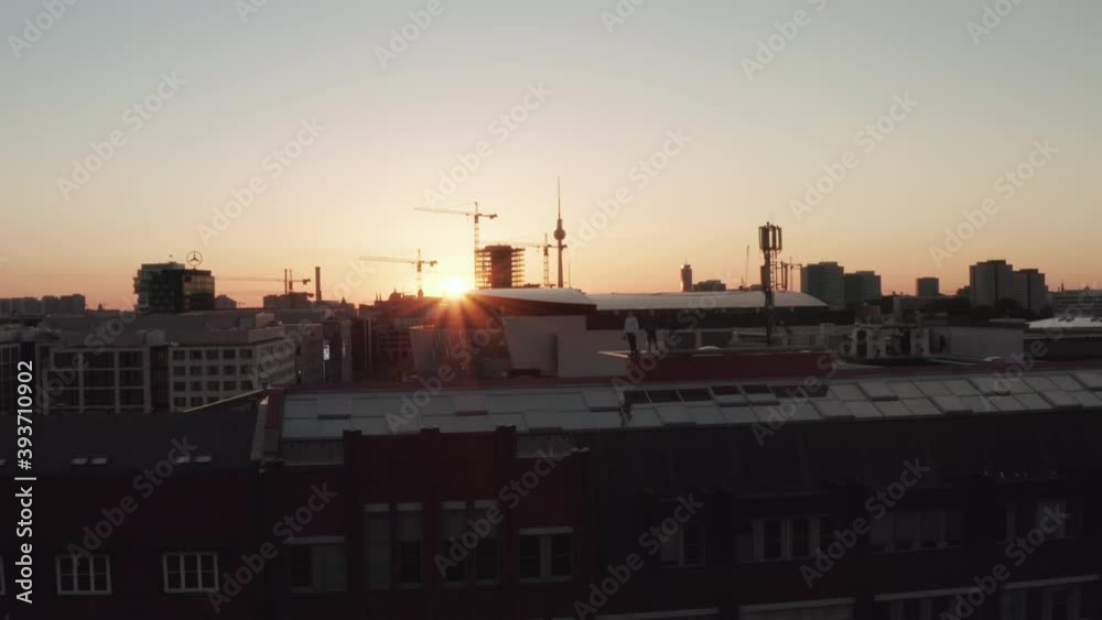 AERIAL: Confident Young Man, Guy standing on rooftop in Skyline of Berlin, Germany with Beautiful Sunlight in Summer Vibe AERIAL: Confident Young Man, Guy standing on rooftop in Skyline of Berlin, Germany with Beautiful Sunlight in Summer Vibe