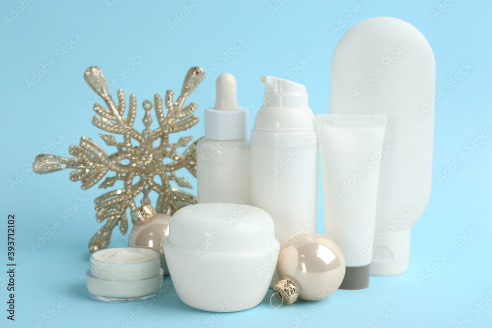 Beautiful composition with cosmetic products on light blue background. Winter care Beautiful composition with cosmetic products on light blue background. Winter care