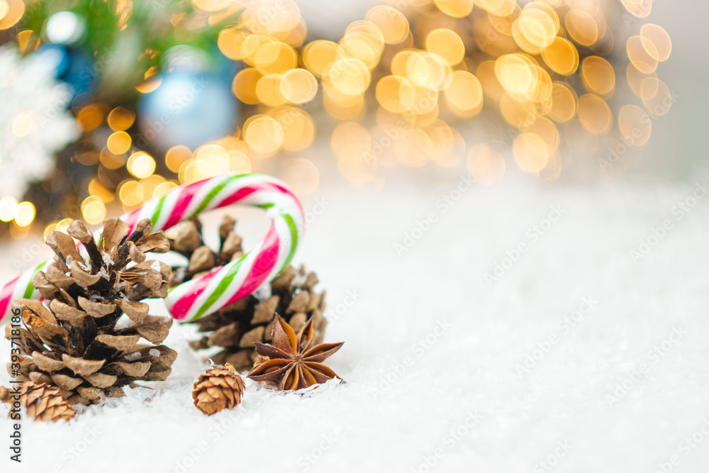 Pine cones, candy stick, anis star on the snow. Christmas composition with copy space. 