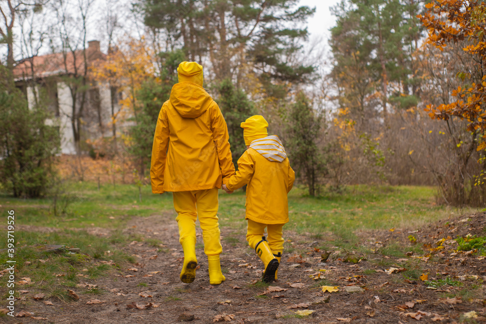 Cute little boy and a girl - brother and sister - in identical yellow costumes and hats walking in the forest. Cosiness, family Cute little boy and a girl - brother and sister - in identical yellow costumes and hats walking in the forest. Cosiness, family