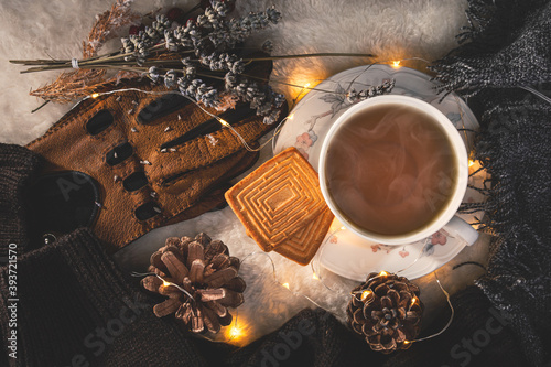 Quadro em tela high angle picture of  a hot cup of tea and two biscuits,warm lights surround th
