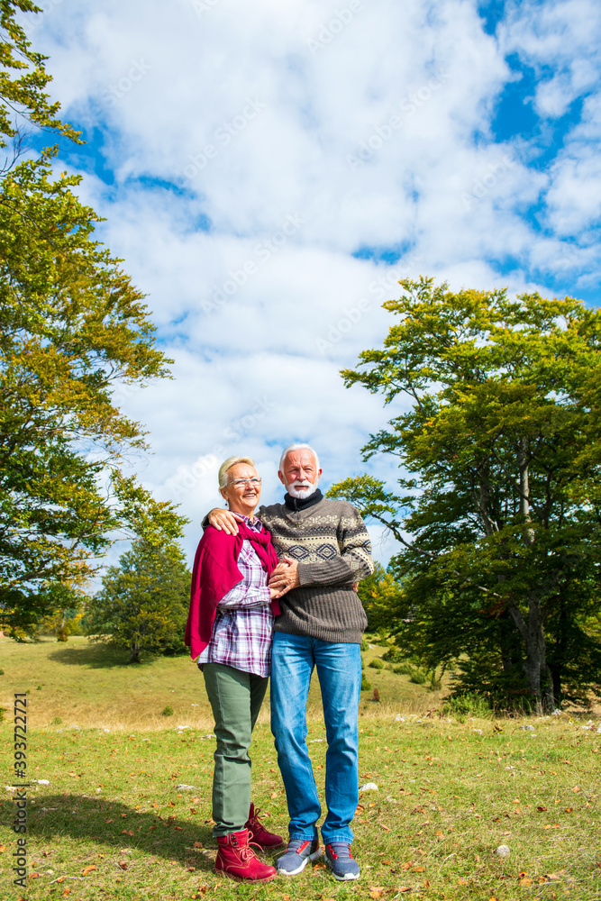 Fototapeta premium Senior couple on a walk in an autumn nature.