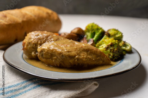 Chicken in mustard sauce with roasted vegetables in white background