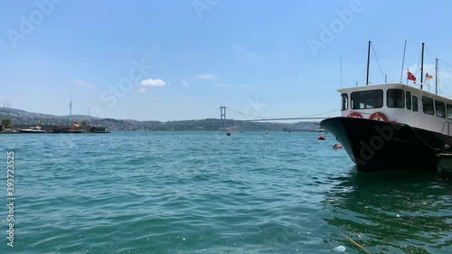 Footage of moored yachts and boats by Bosphorus in Kurucesme area of Istanbul. Garbage is in the water. Asian side is in the view. It is a sunny summer day. photo