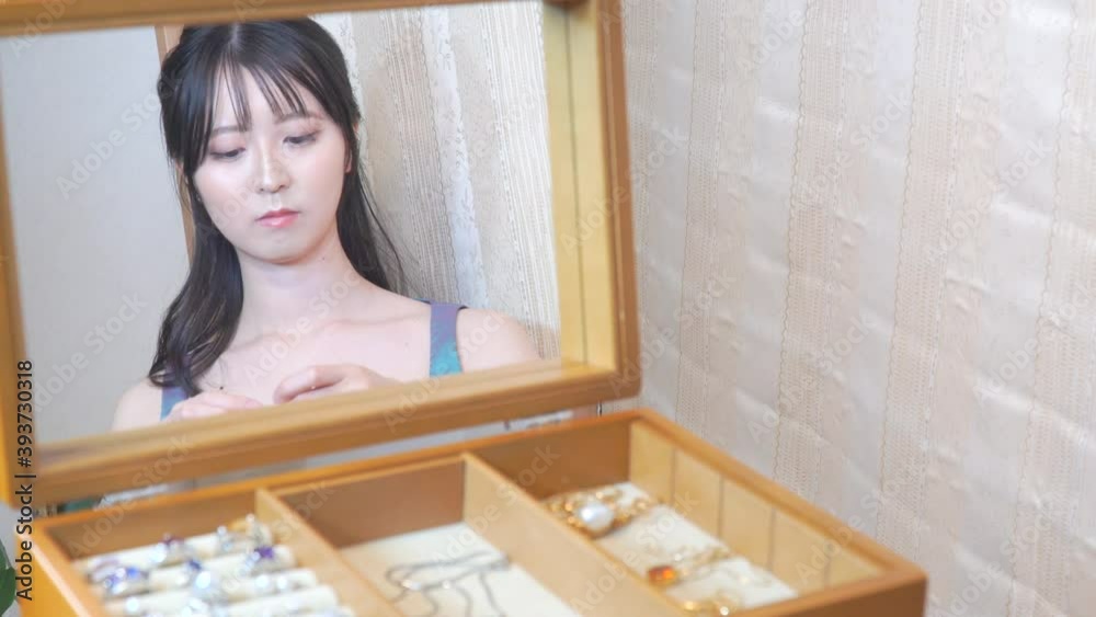 ダイヤのネックレスをつけて鏡を見る女性 ダイヤのネックレスをつけて鏡を見る女性