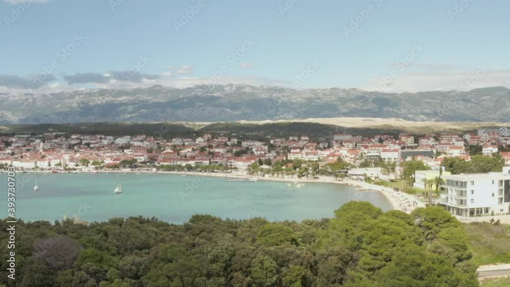 AERIAL: Flight over turquoise blue ocean, land in Novalja, Croatia Nature with houses and blue sky and sun AERIAL: Flight over turquoise blue ocean, land in Novalja, Croatia Nature with houses and blue sky and sun