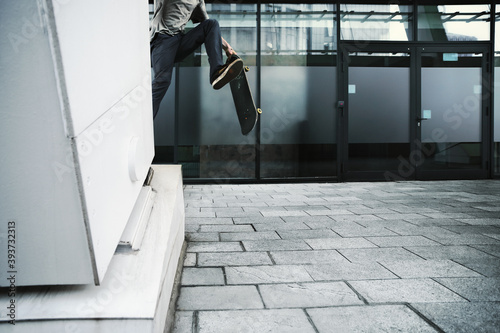 Young Caucasian man jumping on a skateboard on the street.
