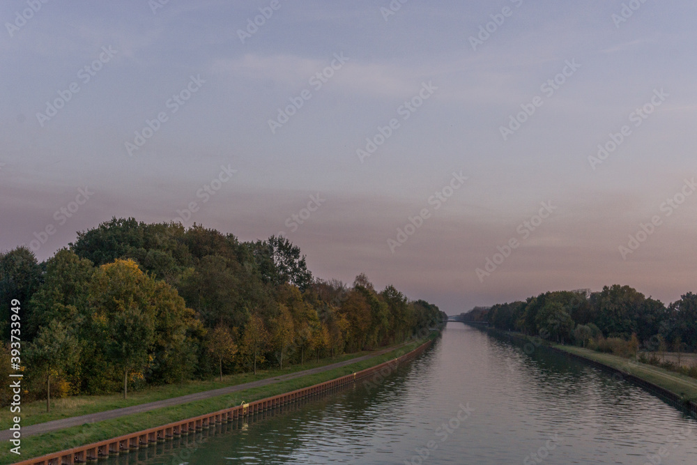 Straight water channel in germany munsterland at sunset in autumn