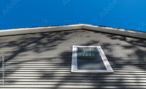 New window treatments and vinyl siding on residential home; real estate development background concept