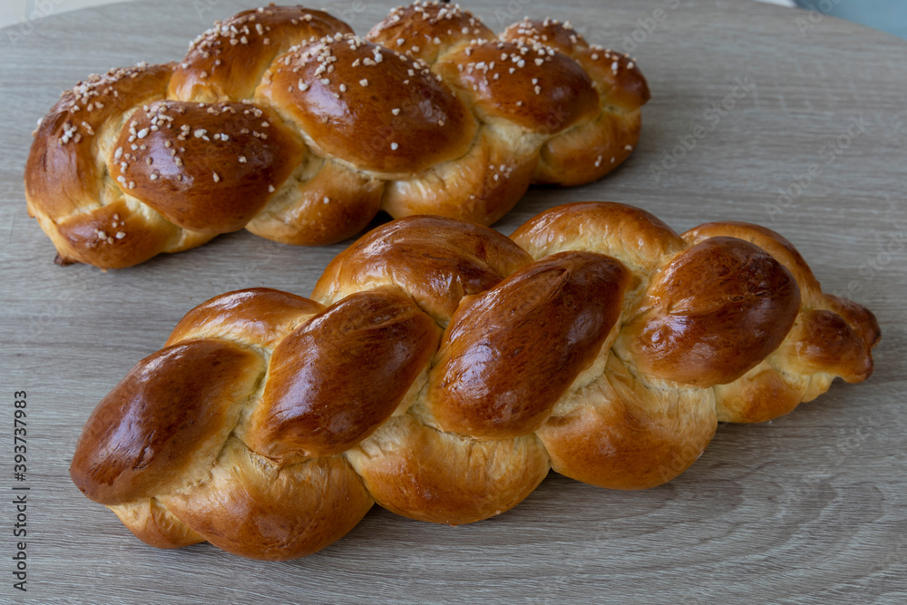 Two braided Brioche breads on wooden board Two braided Brioche breads on wooden board