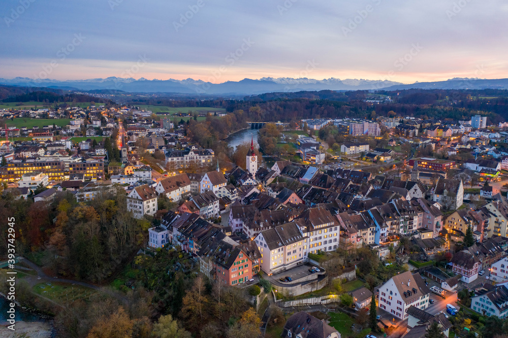 sunset over a medieval town with view of the alps