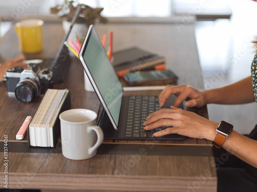 Fotografi Side view of female hand working with laptop on worktable in office room