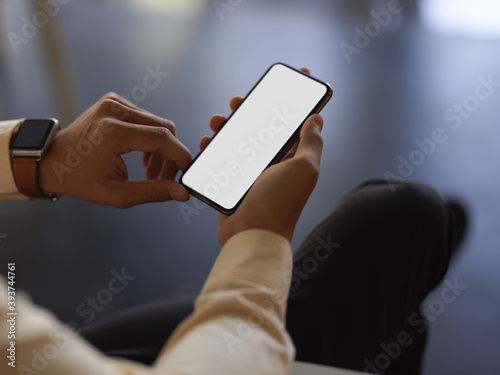 Businessman hands using smartphone while relaxed sitting in office room