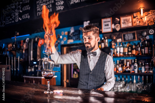 Barman concocts a cocktail behind the bar