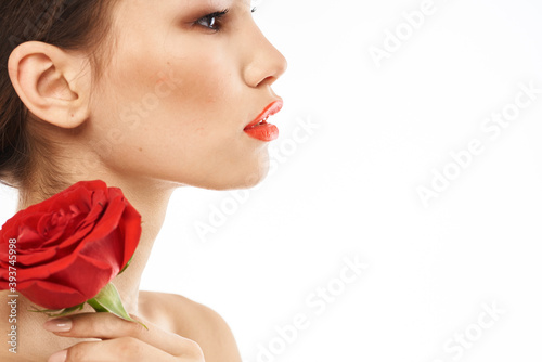Beautiful woman with red rose near face makeup naked shoulders portrait