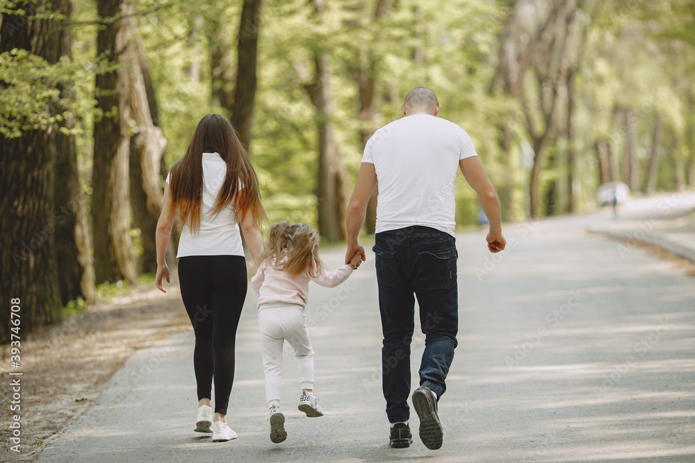 Family in a summer forest. Woman and man in a white t-shirts. Daughter with parents. Family in a summer forest. Woman and man in a white t-shirts. Daughter with parents.