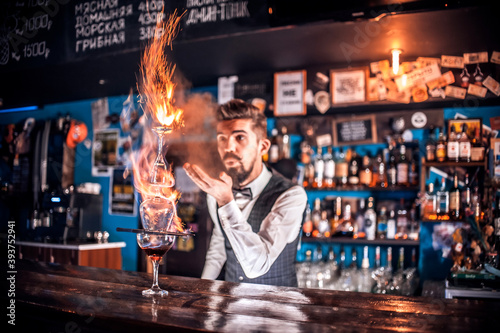 Professional mixologist decorates colorful concoction at the nightclub photo