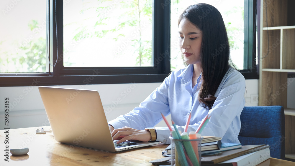 Portrait of female graphic designer working with laptop in creative office. Portrait of female graphic designer working with laptop in creative office.